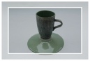 Green coffee mug on upturned saucer