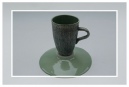 Green coffee mug on upturned saucer
